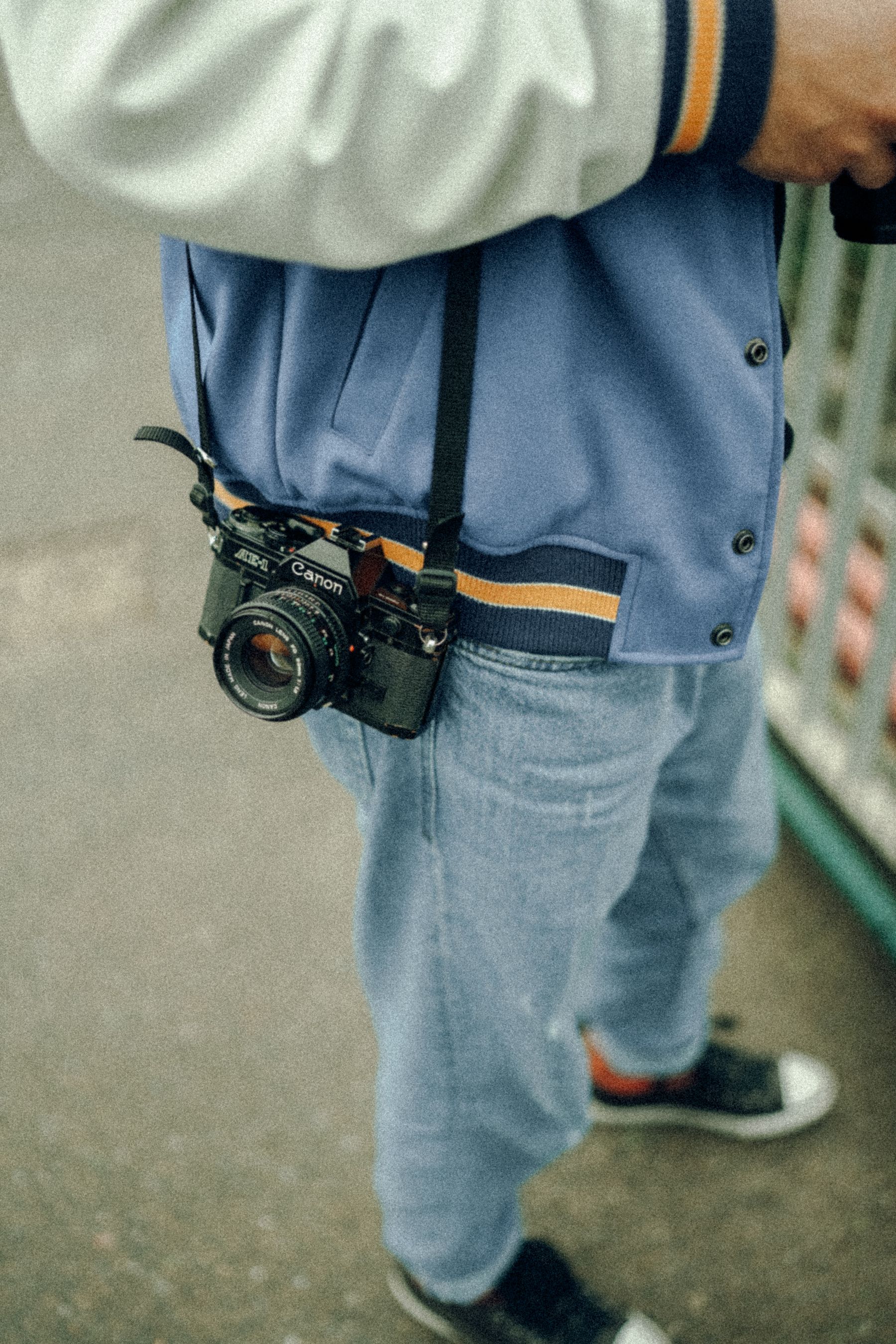 Figure with a camera slung over the shoulder, film tones